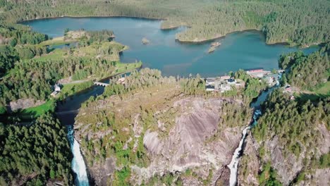 Tilt-up-aerial-shot-over-two-large-waterfalls-in-Norway-with-lake-Lotevatnet-in-the-background