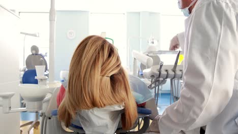 dentist examining a woman teeth in the dentists chair