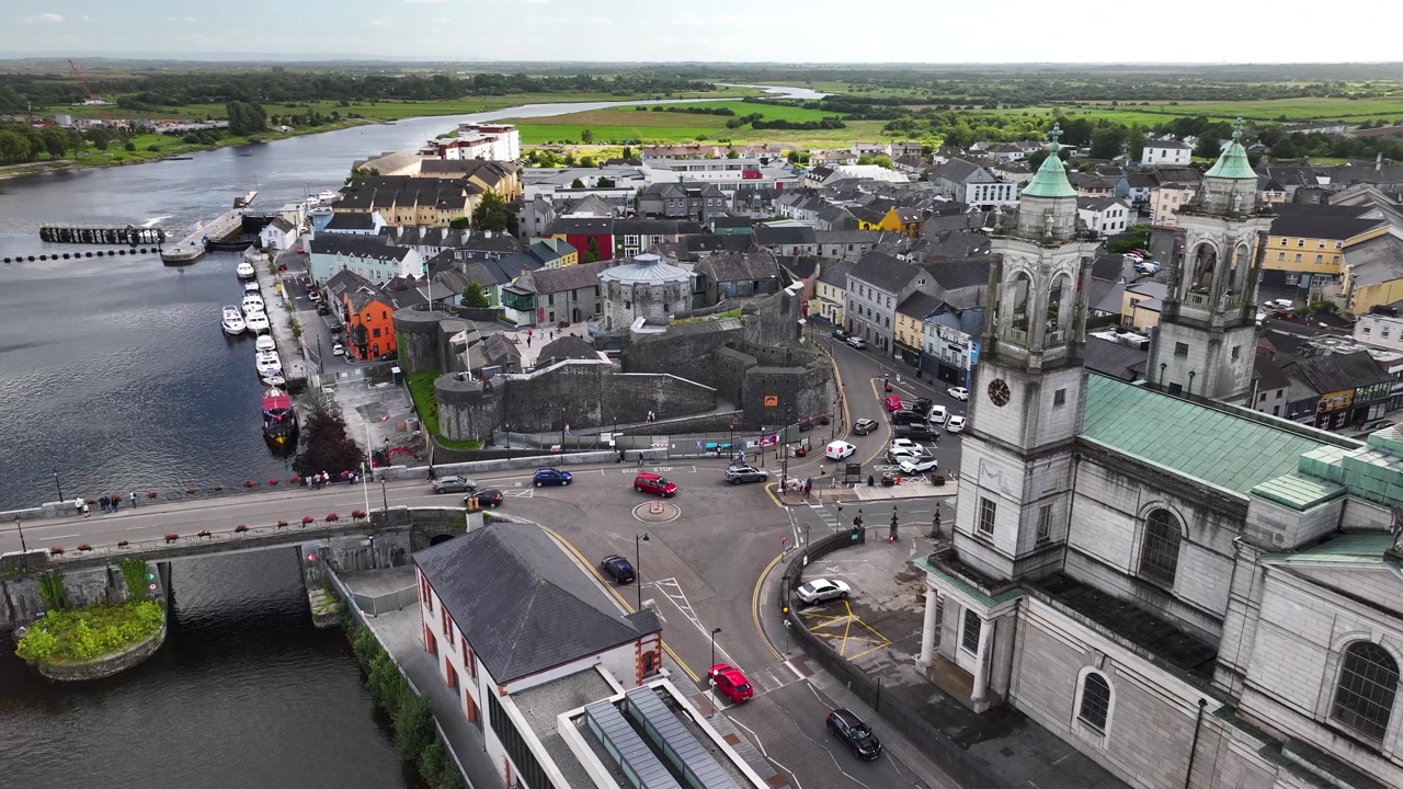 Dynamic drone close up of Athlone Castle and Church tower, small Irish town on river.