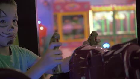 a boy with a painted cat snout on a face playing a game machine