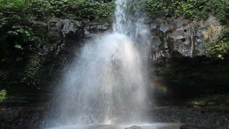 arco iris borroso detrás de una cascada fresca