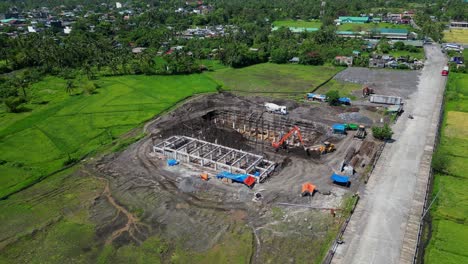 aerial pullback of construction area in malilipot, albay bare metal beams exposed surrounded by green landscape and hills