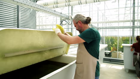 Man-Checking-Equipment-in-Flower-Greenhouse