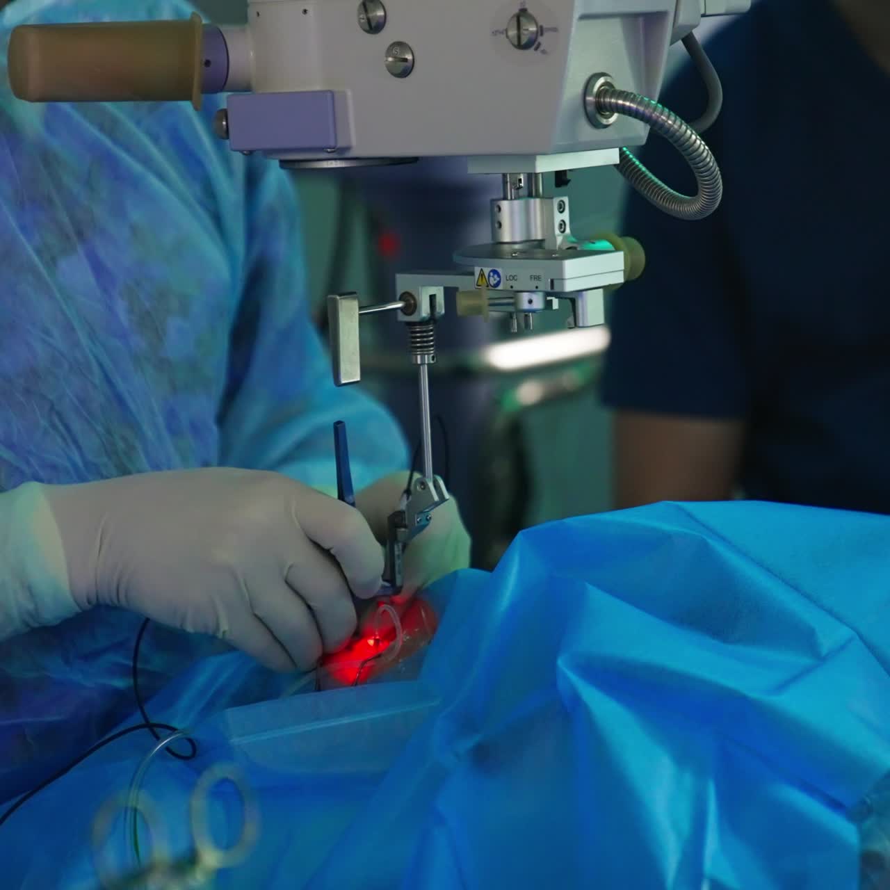 Doctor operating eye using little device with tube. Advanced equipment over the patient sending red light into the operated organ