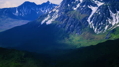 majestic mountain range with lush valleys and snowy peaks under bright sky