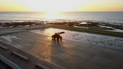 Aerial-orbits-tractor-cleaning-pool-at-Mereweather-Beach-ocean-baths