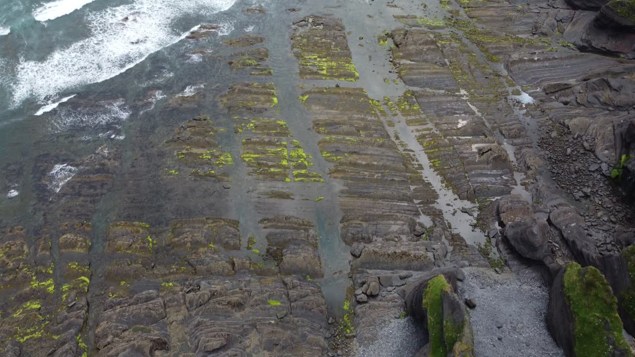 vista aérea de las olas del océano salpicadas de rocas,