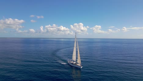 Malerische-Szenerie-Einer-Luxuriösen-Austern-Segelyacht,-Die-Auf-Flachem-Meer-Mit-Perfektem-Blauem-Himmel-Und-Geschwollenen-Wolken-Am-Horizont-Kreuzt