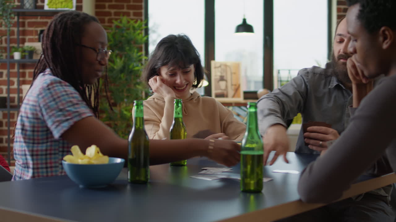 Diverse group of friends playing cards at fun gathering