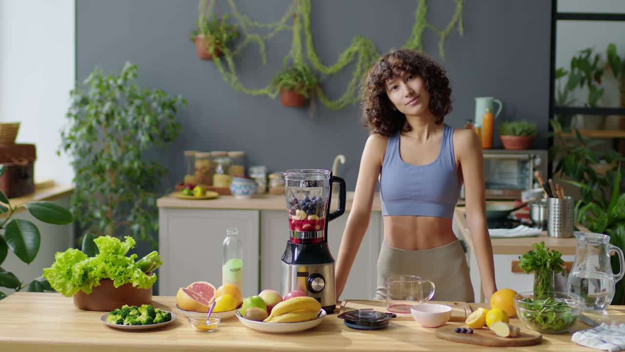 Portrait of Young Fit Woman with Fresh Fruit and Blender in Kitchen