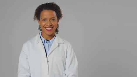 studio portrait of smiling female doctor or lab worker wearing white coat