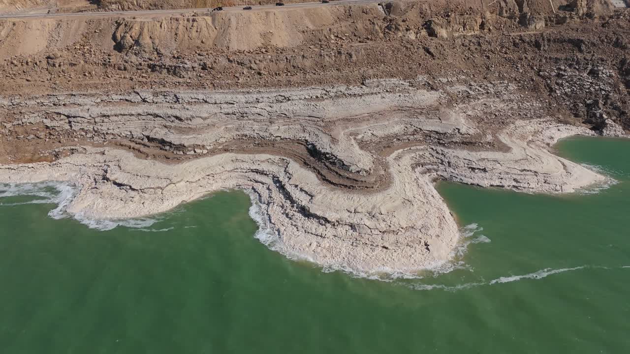 Prospettiva aerea degli esclusivi cristalli di sale bianchi e delle acque minerali turchesi lungo le rive del Mar Morto in Giordania