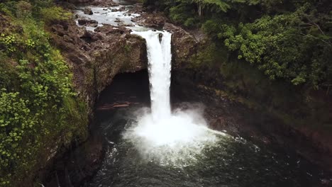 Cinematic-Drone-Shot-panning-up-and-revealing-a-gushing-Rainbow-Falls-right-after-a-rain-storm