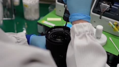 A-close-up-shot-of-a-worker-attaching-screws-to-a-lens