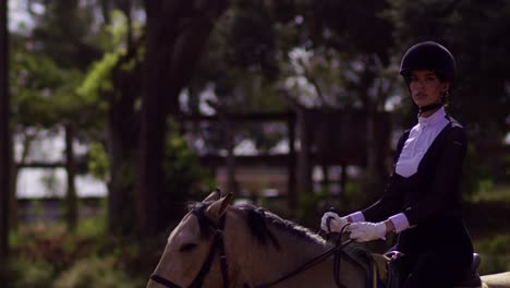 a girl equestrian athlete rides on horse in slow motion closeup