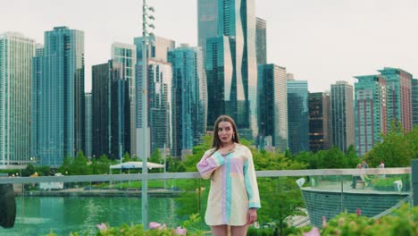 beautiful-caucasian-girl-surprised-covering-mouth-by-hand,-Daylight,-outside-in-chicago-with-skyscrapers-in-background-and-green-bushes-in-foregrround