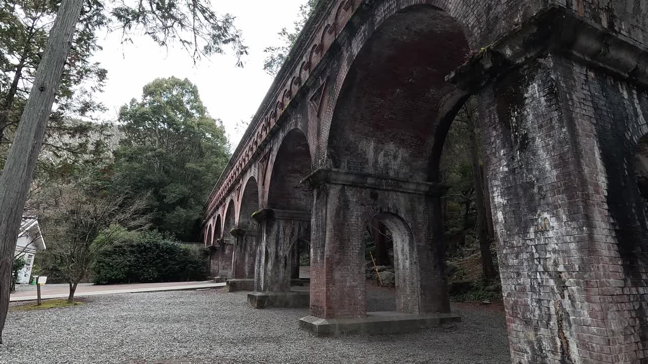 The red brick Suirokaku Aqueduct arches through Nanzen-ji Temple grounds, blending Meiji-era engineering with serene temple surroundings.