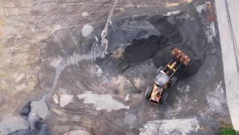 drone over sand quarry with heavy machinery.the truck and excavator.the truck drives up to the excavator for sand and crushed stone loading