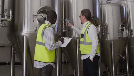 un homme caucasien et afro-américain travaillant dans une microbrasserie.