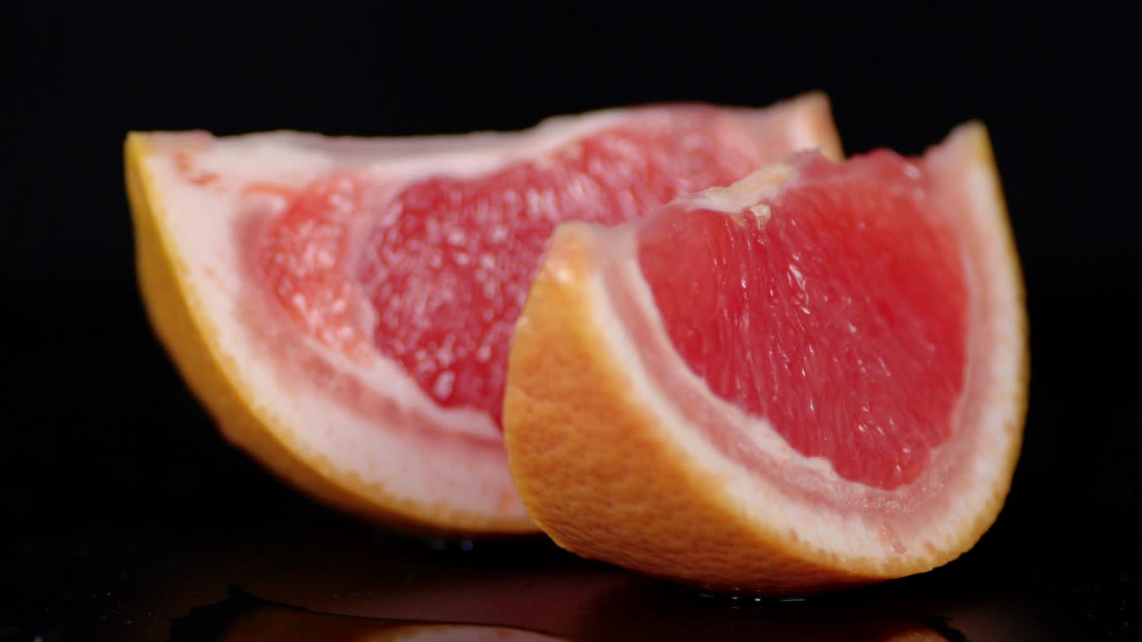 Juicy pieces of grapefruit slowly rotate.