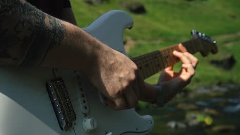 hombre tocando la guitarra frente a una hermosa cascada en islandia-6