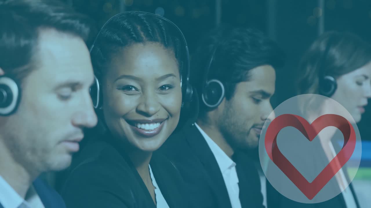 Animation of heart appearing over happy diverse female and male consultants at work