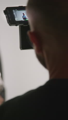 a cameraman filming a person on a white background