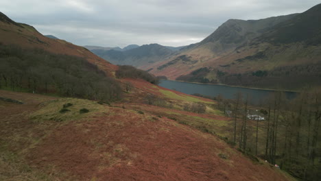 flying towards dark lake surrounded by mountains in english lake district uk