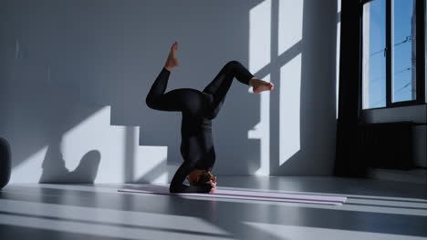 woman doing a headstand yoga pose