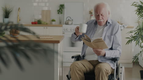 senior man reading in wheelchair at home kitchen