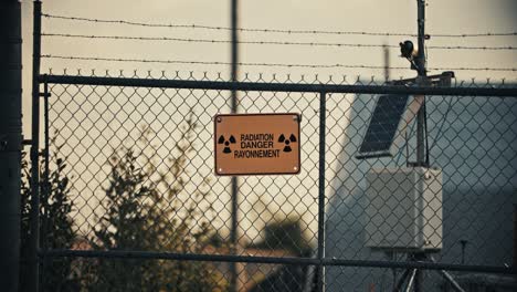 Radiation-Danger-Sign-on-Barbed-Wire-Fence-with-Butterfly-in-Slow-Motion-4K