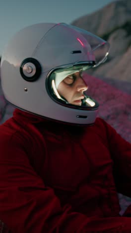 el astronauta se sienta cansado en una roca seca por la noche antes de dormir triste