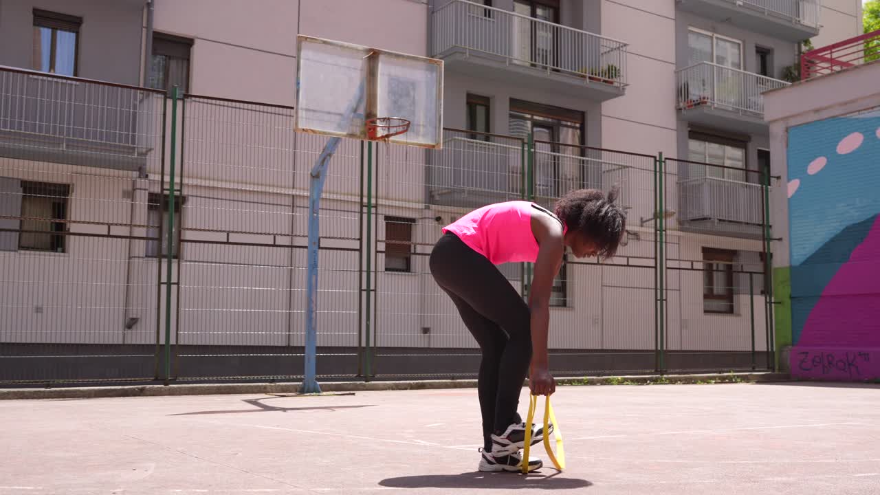 Kvinde, der træner på en basketballbane