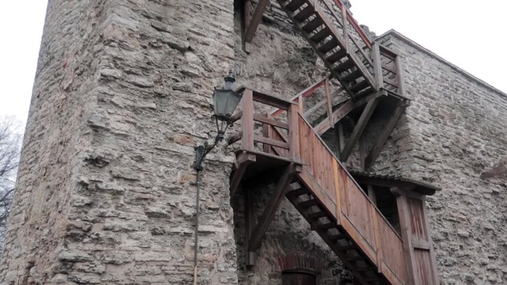Vista da terra del muro di fortificazione medievale e di un'antica scalinata in legno nella città vecchia di Tallinn