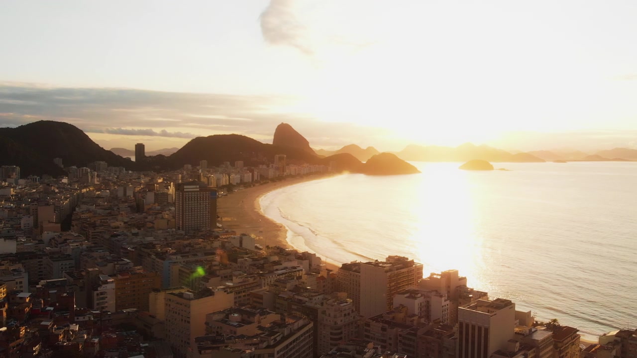 Luchtpan veegt van de skyline van Rio richting Copacabana en de zonsondergang bij de Suikerbroodberg.