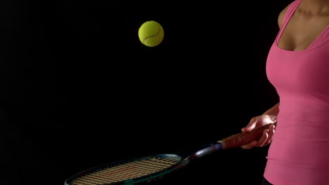 Fit-woman-in-pink-bouncing-a-tennis-ball-on-racket