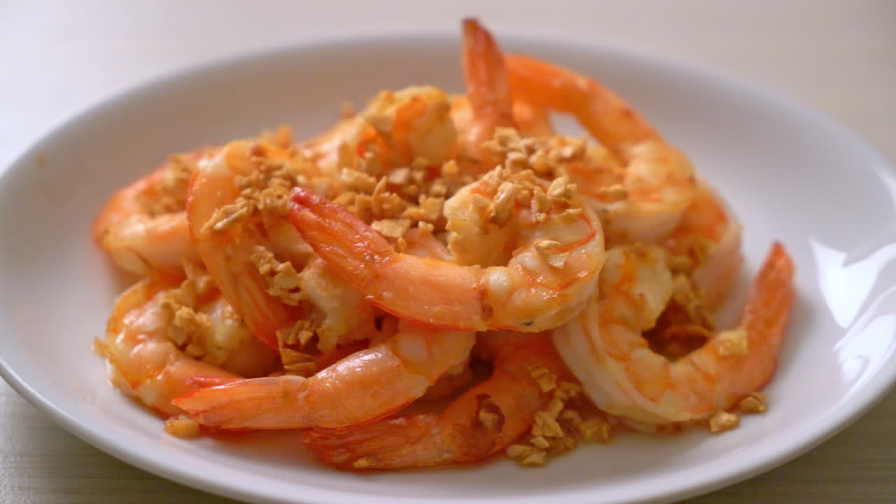 camarones fritos o langostinos con ajo en plato blanco - estilo mariscos