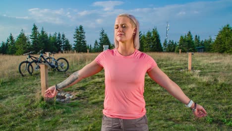 Orbit-shot-of-a-woman-standing-with-her-eyes-closed-on-a-healing-energy-point-in-Slovenia