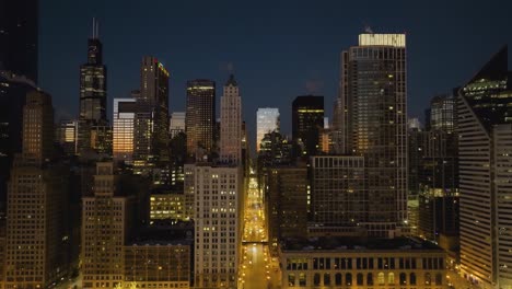 Aerial-view-of-the-illuminated-East-Washington-street,-dusk-in-Chicago,-USA---reverse,-drone-shot