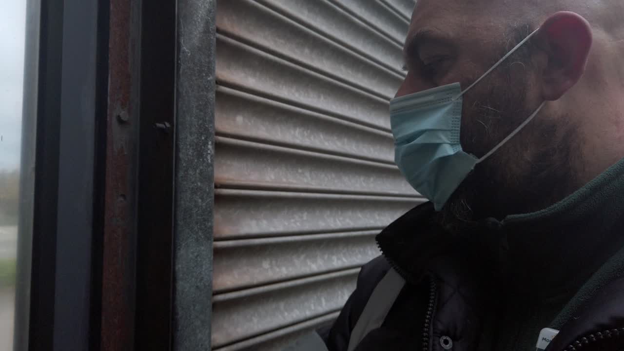 macho abriendo la persiana enrollable de seguridad corrugada con máscara facial de virus ppe corona