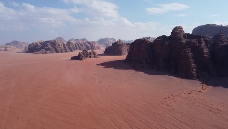 great view of two cars driving through the wadi rum desert with rock mountains in jordan