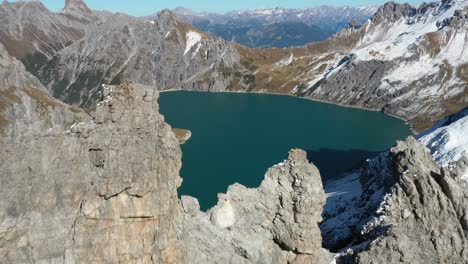 toma aérea moviéndose hacia atrás sobre los escarpados acantilados alrededor del lago love heart en la cima de la montaña lunersee en suiza durante un día claro y soleado en el verano.