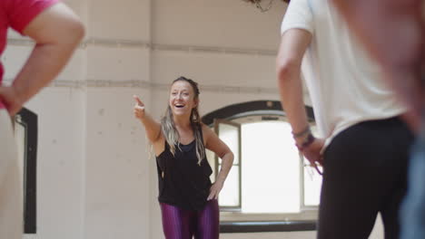 Long-shot-of-female-dance-teacher-learning-movements-with-group