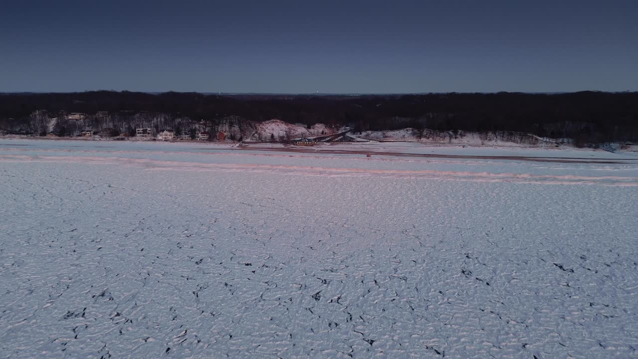 Experience an aerial drone view of ice-covered Lake Erie, showcasing the frozen waters and the expansive winter landscape in striking detail.