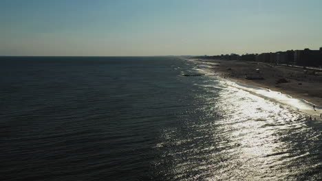 Vuelo-De-Cámara-De-Drones-Sobre-El-Océano-Hacia-El-Sol-Poniente-Que-Brilla-En-Las-Aguas-Debajo