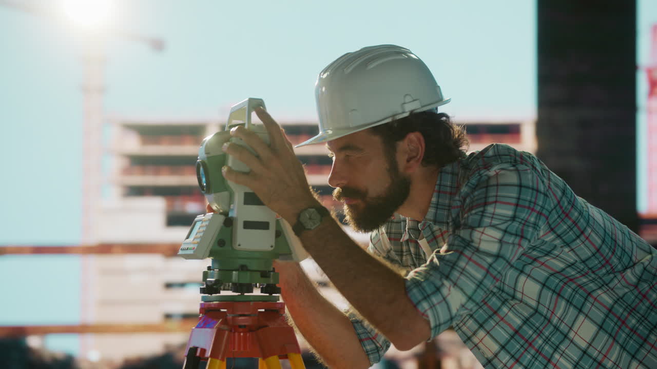 Surveyor or Engineer Using a Total Station at a Construction Site