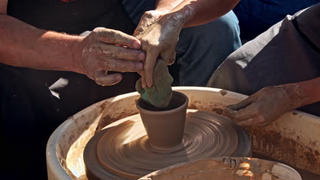 potter working with apprentice