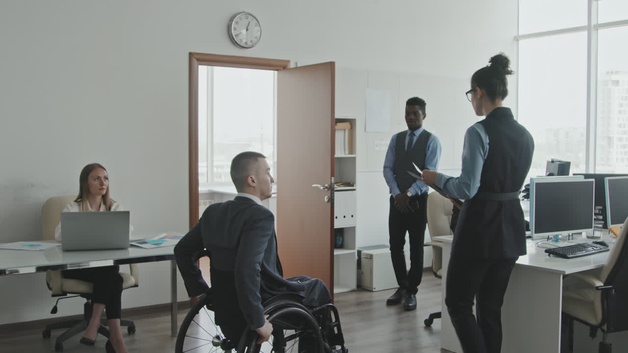 Imprenditori che salutano un dirigente in sedia a rotelle
