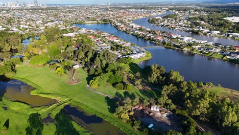 drone footage captures a lush wetlands park with adjacent cityscape under bright daylight, showcasing natural and urban harmony
