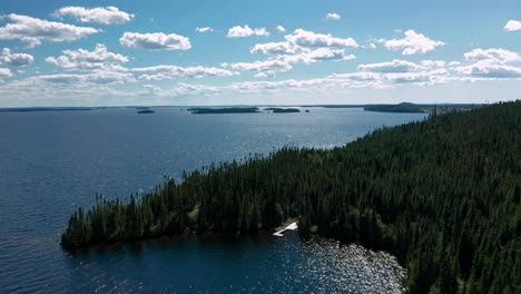 drone flying over an isolated dock in a large forest and lake